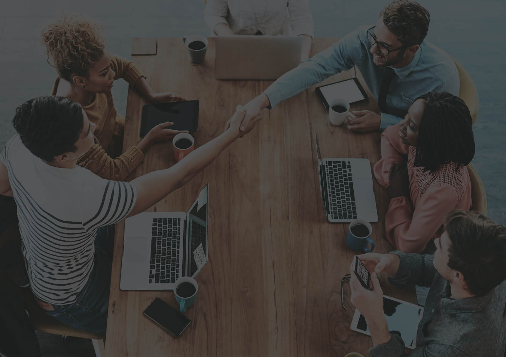 Shot of a colleagues shaking hands during a meeting in a modern office
