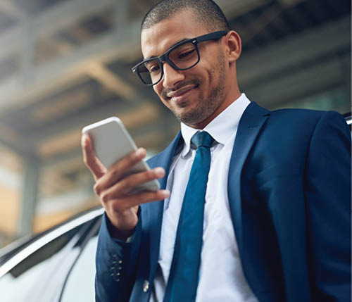 Shot of a businessman using his phone while standing outside