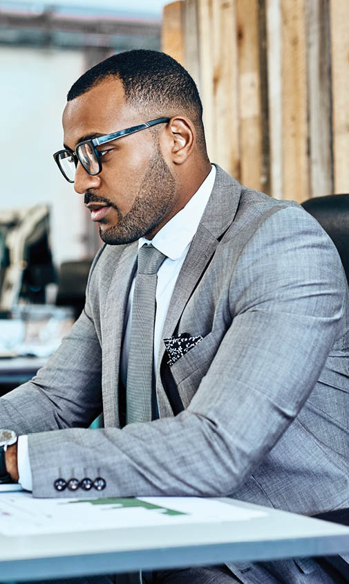 Shot of a young businessman working on a laptop in an office