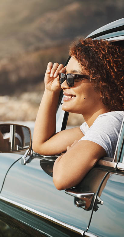 Shot of a young woman enjoying a road trip