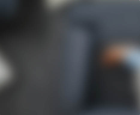 High angle shot of an attractive young woman using her cellphone while relaxing on a couch at home