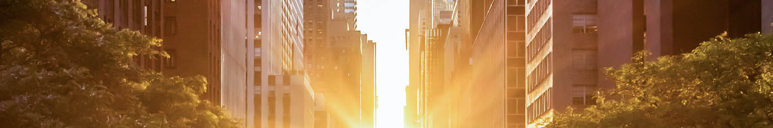 Sunset light shining on the buildings and cars on 42nd Street in Midtown New York City around the time of the Manhattanhenge summer solstice